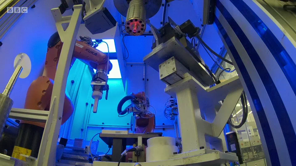 A blue-lit robotic factory cell in BBC's The Digital Factory