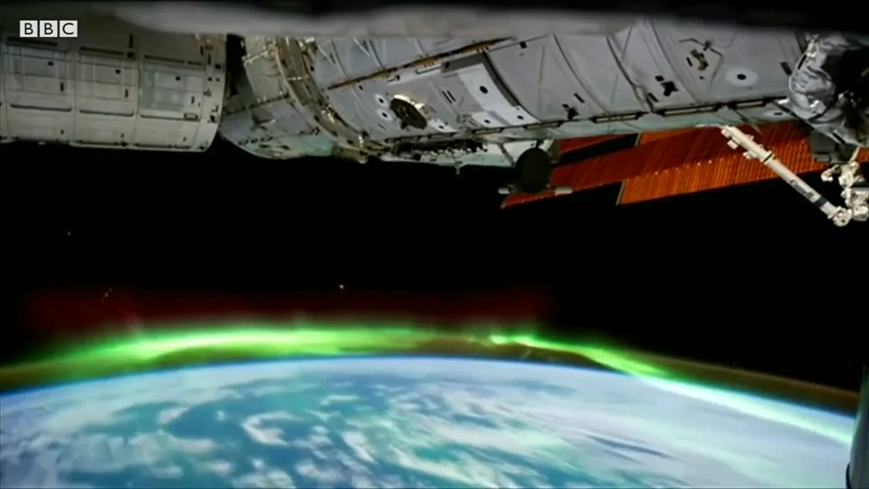The International Space Station above Earth's green aurora in BBC's The New Space Race